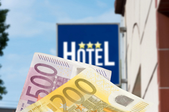 Bild zeigt Euroscheine und eine Tafel mit der Aufschrift Hotel 